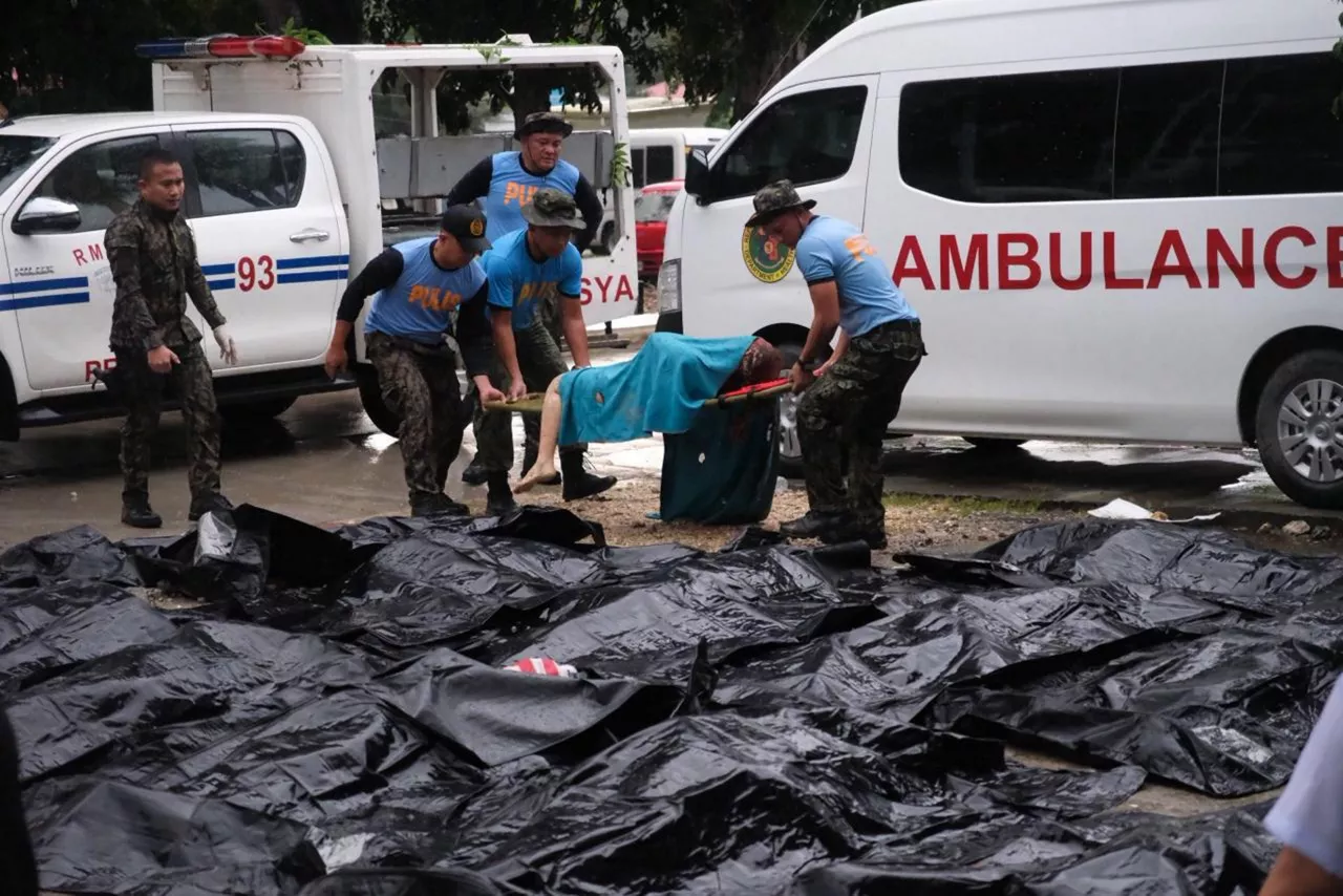 BOGO (Philippines), 01/10/2025.- Policemen carry a victim past cadaver bags in the aftermath of an earthquake in Bogo city, Cebu island, Philippines, 01 October 2025. According to a statement by the Cebu island Provincial Disaster Risk Reduction and Management Office (PDRRMO) released on 01 October, at least 61 people were killed following a 6.9-magnitude earthquake that struck off the coast of Cebu Island on 30 September. The earthquake’s epicenter was located near Bogo City. (Terremoto/sismo, Filipinas) EFE/EPA/JUANITO ESPINOSA EDITORS NOTE: GRAPHIC CONTENT

