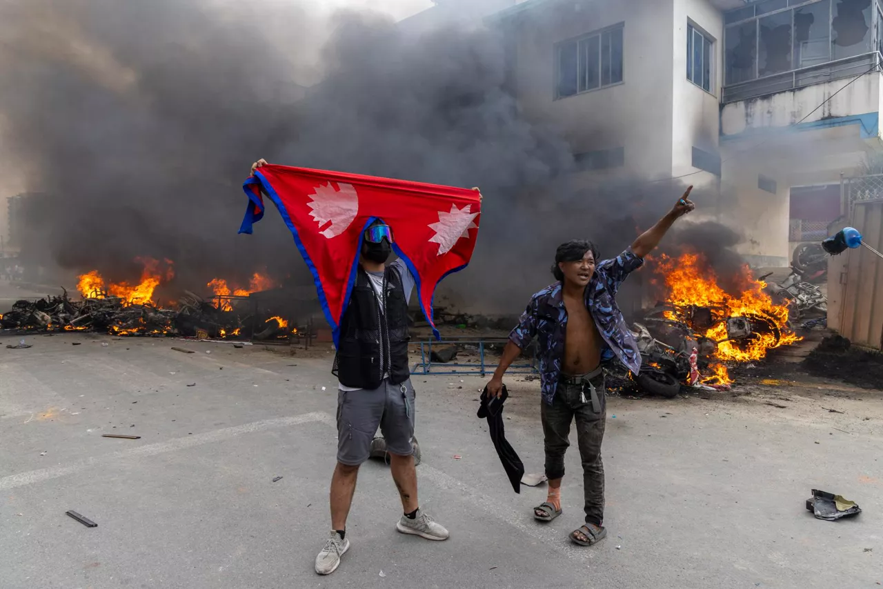 Kathmandu (Nepal), 09/09/2025.- Protesters stand in front of the Communist Party of Nepal - Unified Marxist–Leninist (CPN-UML) office that was set ablaze in Kathmandu, Nepal, 09 September 2025, a day after at least 19 people were killed and dozens injured during demonstrations against corruption and a government social media ban. (Protestas) EFE/EPA/NARENDRA SHRESTHA

