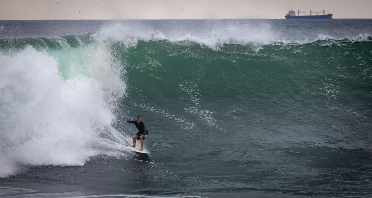 FOTODELDIA SAN SEBASTIÁN, 26/08/2025.- Un surfista aprovecha el oleaje registrado este martes en San Sebastián. El Ayuntamiento donostiarra ha decidido cerrar la isla de Santa Clara al acceso de público durante toda la jornada de este martes, debido al aviso de mala mar y oleaje emitido por Euskalmet.EFE/Javier Etxezarreta
