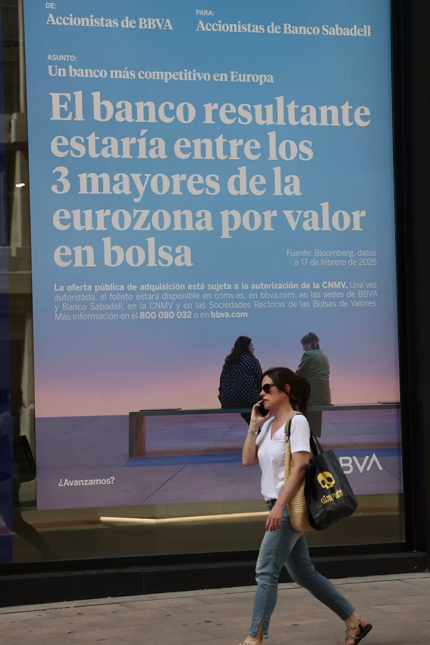 GRAFCAV9210. BILBAO, 24/06/2025.-Un cartel en una sucursal del BBVA, en Bilbao este martes aludiendo a la fusión entre BBVA y Sabadell. La Comisión Europea recordó este martes que cualquier condición impuesta por un Gobierno para aprobar una transacción debería ser "excepcional, proporcionada y justificada por razones de interés público válidas", aunque rehusó pronunciarse en concreto sobre la decisión del Ejecutivo español respecto a la opa del BBVA por el Sabadell. EFE/Luis Tejido
