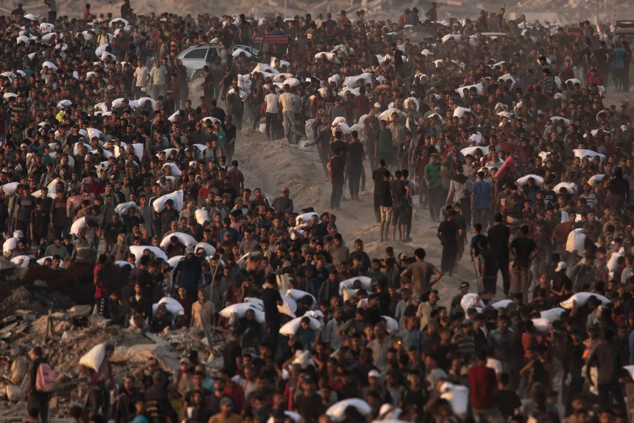 FOTODELDÍA EPA7706. JABALIA (PALESTINA), 17/06/2025.- Palestinos desplazados llevan bolsas de harina por la calle Rashid, en el oeste de Jabalia, el 17 de junio de 2025, después de que camiones de ayuda humanitaria ingresaran al norte de la Franja de Gaza a través del cruce de Zikim, controlado por Israel, al noroeste de la ciudad de Gaza. EFE/EPA/ Haitham Imad
