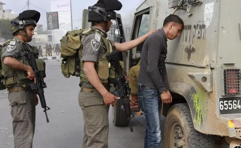 Soldadu israeldar bat gazte palestinarra atxilotzen (artxiboko irudia).