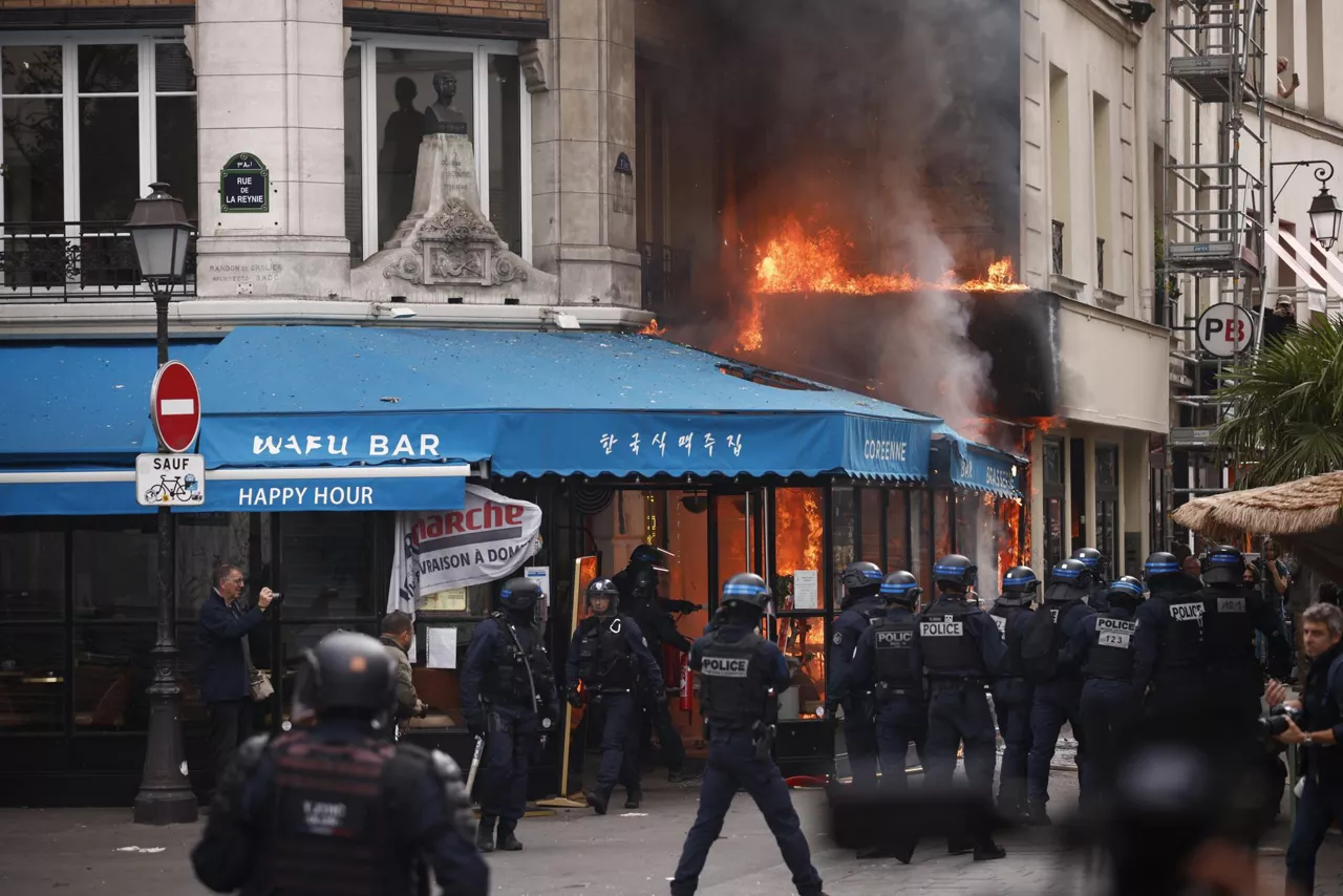 PARIS (France), 10/09/2025.- Police officers secure a perimeter around a restaurant fire after clashes with protesters during a rally against austerity measures following a call for action by the 'Bloquons tout' (Block everything) collective in Paris, France, 10 September 2025. To protest against the outgoing government's austerity budget, an online collective called 'Bloquons Tout' has called for everyone to block the entire country on 10 September with symbolic actions. France will deploy 80,000 police officers and gendarmes with instructions to stand firm against protesters. (Protestas, Francia) EFE/EPA/YOAN VALAT

