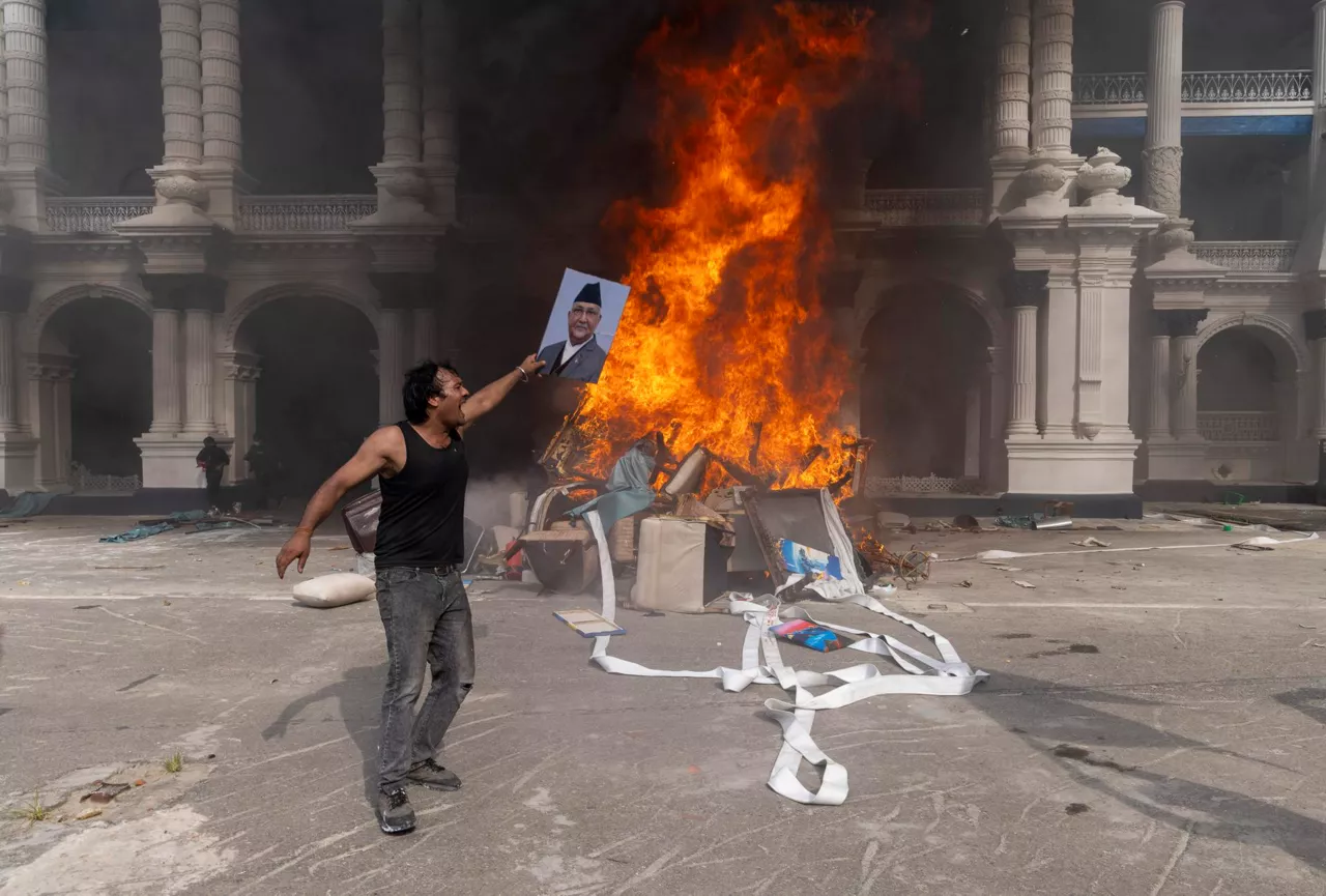 Kathmandu (Nepal), 09/09/2025.- A protester prepares to burn a picture of resigned Prime Minister K.P. Sharma Oli while storming the Singha Durbar palace, which houses government and parliament buildings, during violent demonstrations in Kathmandu, Nepal, 09 September 2025. At least 19 people were killed and dozens injured on 08 September during demonstrations against corruption and a government social media ban. (Protestas) EFE/EPA/NARENDRA SHRESTHA
