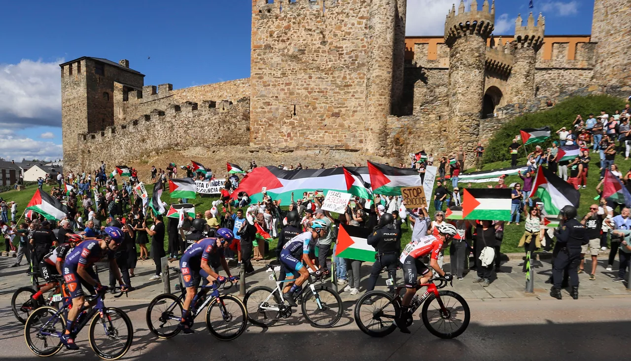 GRAF1079. PONFERRADA (LEÓN), 10/09/2025.- Decenas de personas protestan contra Israel al paso del pelotón por el Castillo de los Templarios en Ponferrada (León), durante la etapa 17 de la Vuelta Ciclista a España, disputada este miércoles entre O Barco de Valdeorras (Ourense) y Alto de El Morredero (EL Bierzo-León) y con 143,2km de recorrido. EFE/ Ana F Barredo
