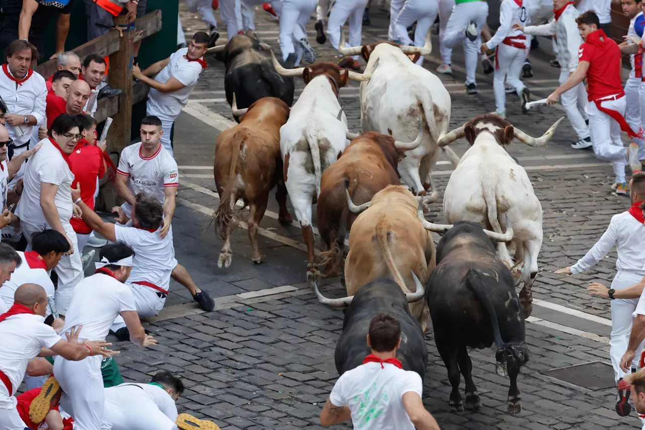 PAMPLONA, 11/07/2025.- Los toros de la ganadería Jandilla persiguen a los mozos durante el quinto encierro de los Sanfermines este viernes en Pamplona. EFE/Villar López
