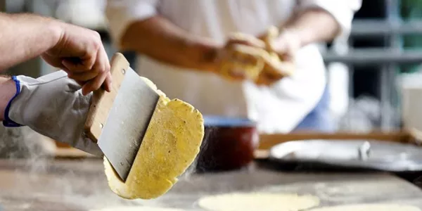 Unos jóvenes preparan talos. Efe