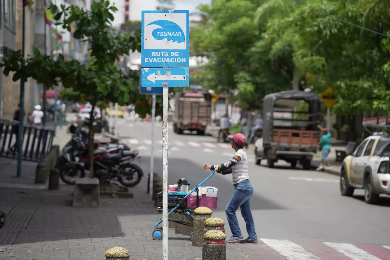AME6470. BUENAVENTURA (COLOMBIA), 30/07/2025.- Una persona camina junto a un cartel que indica una ruta de evacuación este miércoles, en Buenaventura (Colombia). En toda la costa Pacífica de Colombia se generó una alerta de tsunami por el terremoto de magnitud 8.8 en Rusia. EFE/ Ernesto Guzmán
