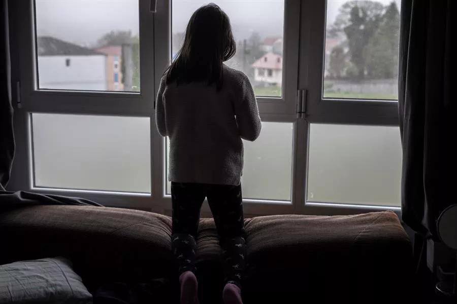 Una niña mira por la ventana durante el confinamiento del año pasado. Foto de archivo: EFE