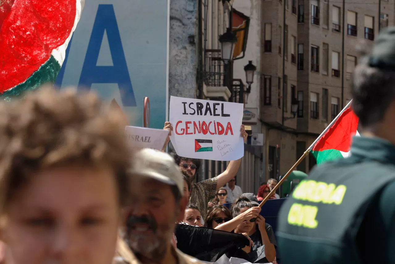 NAVA (ASTURIAS), 05/09/2025.- Decenas de personas con banderas de Palestina condenan el genocidio en Gaza al paso de los corredores por la localidad asturiana de Nava, durante la etapa 13 de la Vuelta Ciclista a España 2025 disputada entre el Cabezón de la Sal, y L'Angliru, de 202,7km de recorrido, este viernes. EFE/Juan González.
