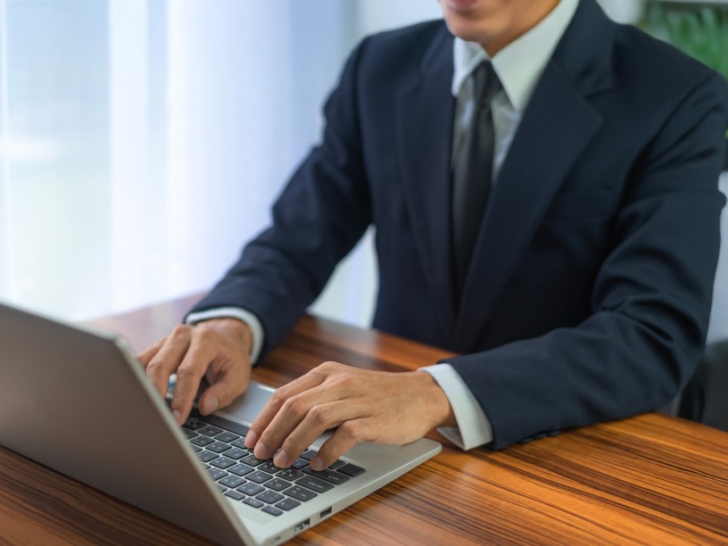 People using computer Side view of male hands typing on laptop keyboard