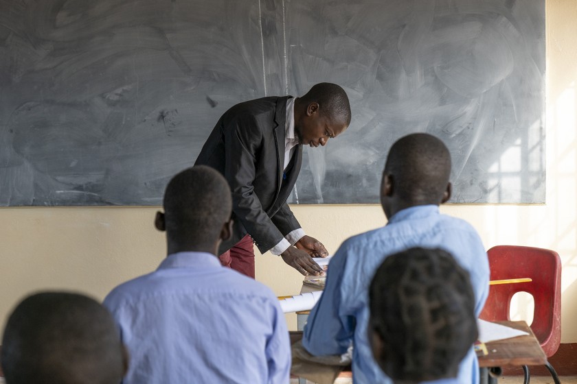 un insegnanete alla lavagna e un gruppo di ragazzi che ascoltano
