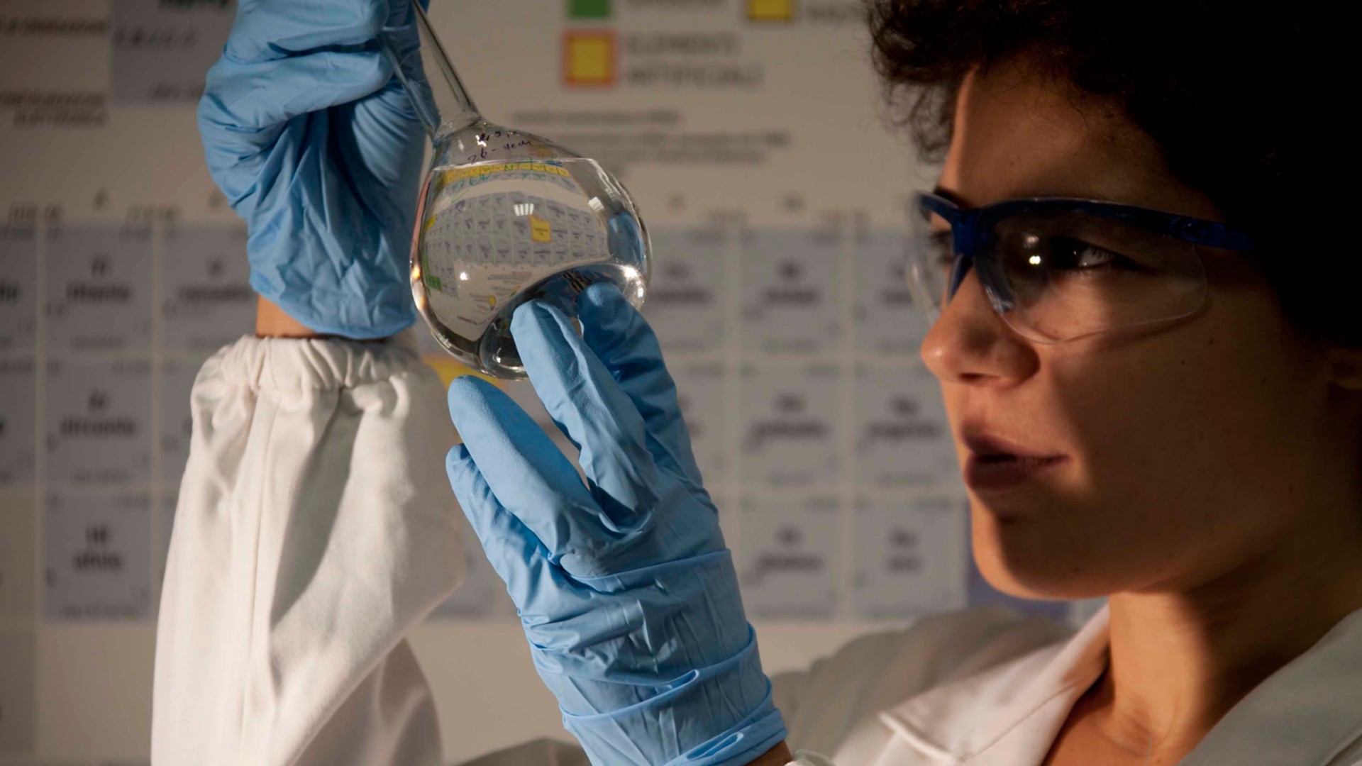 Scienziata guarda provetta in laboratorio