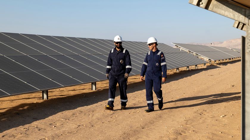 Two men talk walk in the solar panel plant in the Egyptian desert