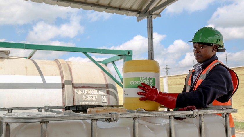 African worker holding a container of used oil