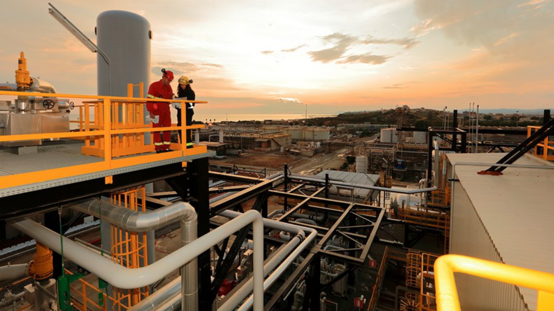 View of the Gela plant at sunset with two workers