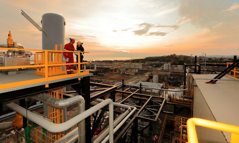 View of the Gela plant at sunset with two workers