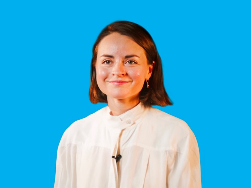 una ragazza sorridente con i capelli neri e una camicia bianca