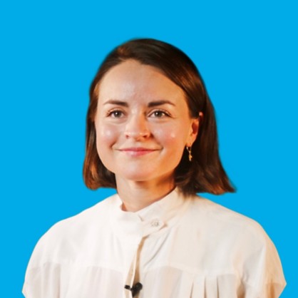 una ragazza sorridente con i capelli neri e una camicia bianca