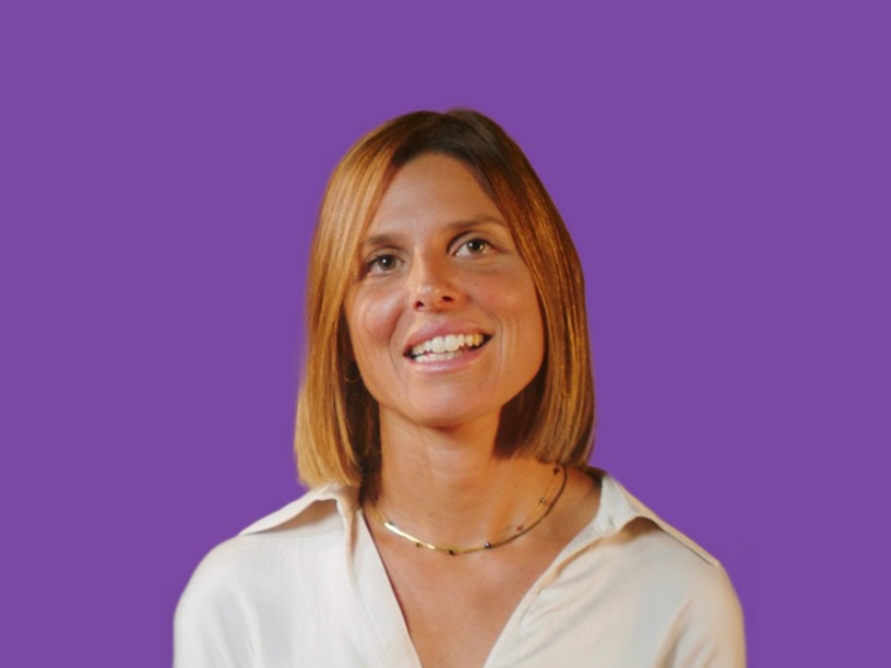 una ragazza sorridente con i capelli biondi e un vestito bianca