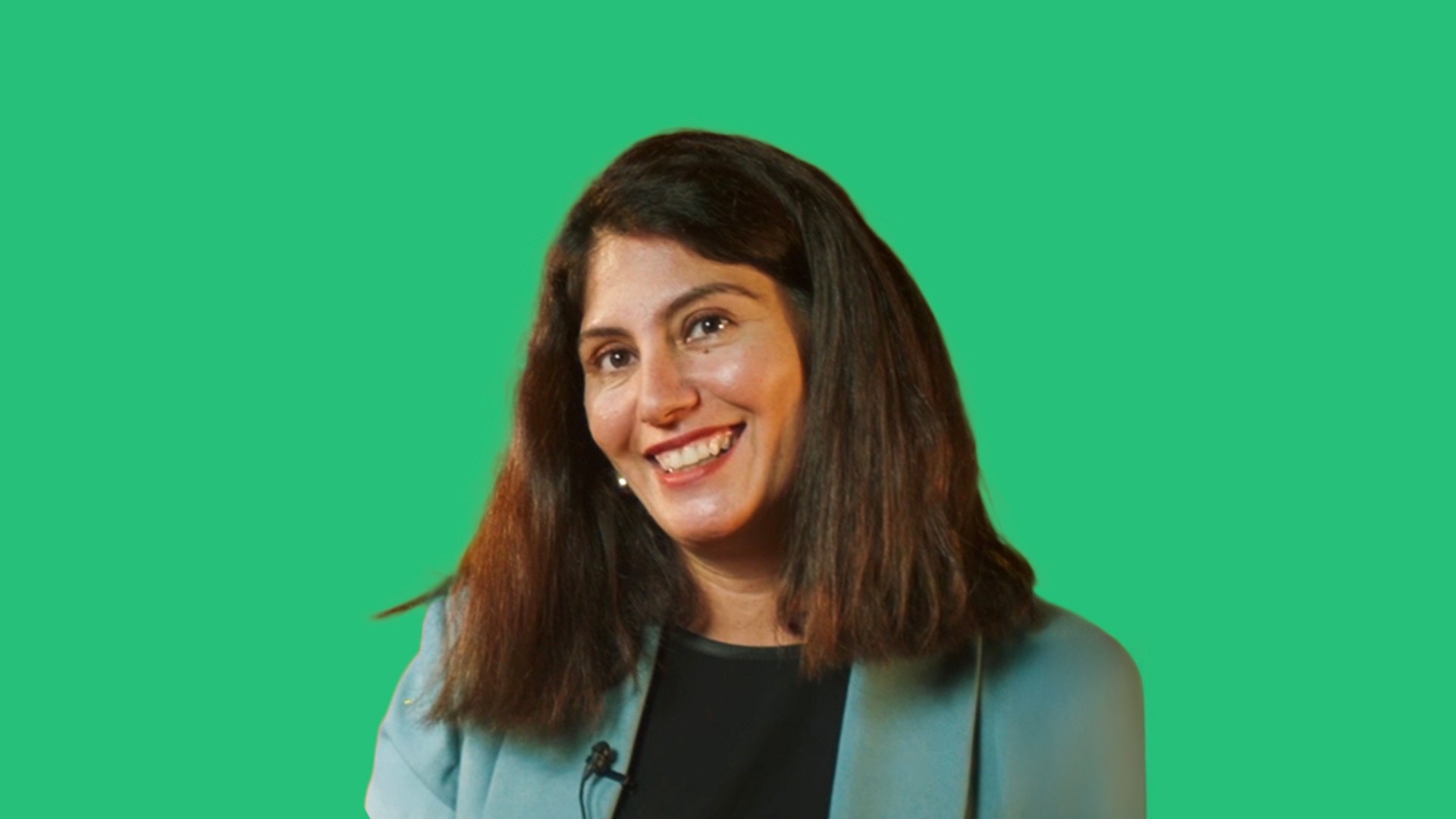 A smiling girl with black hair and a green dress