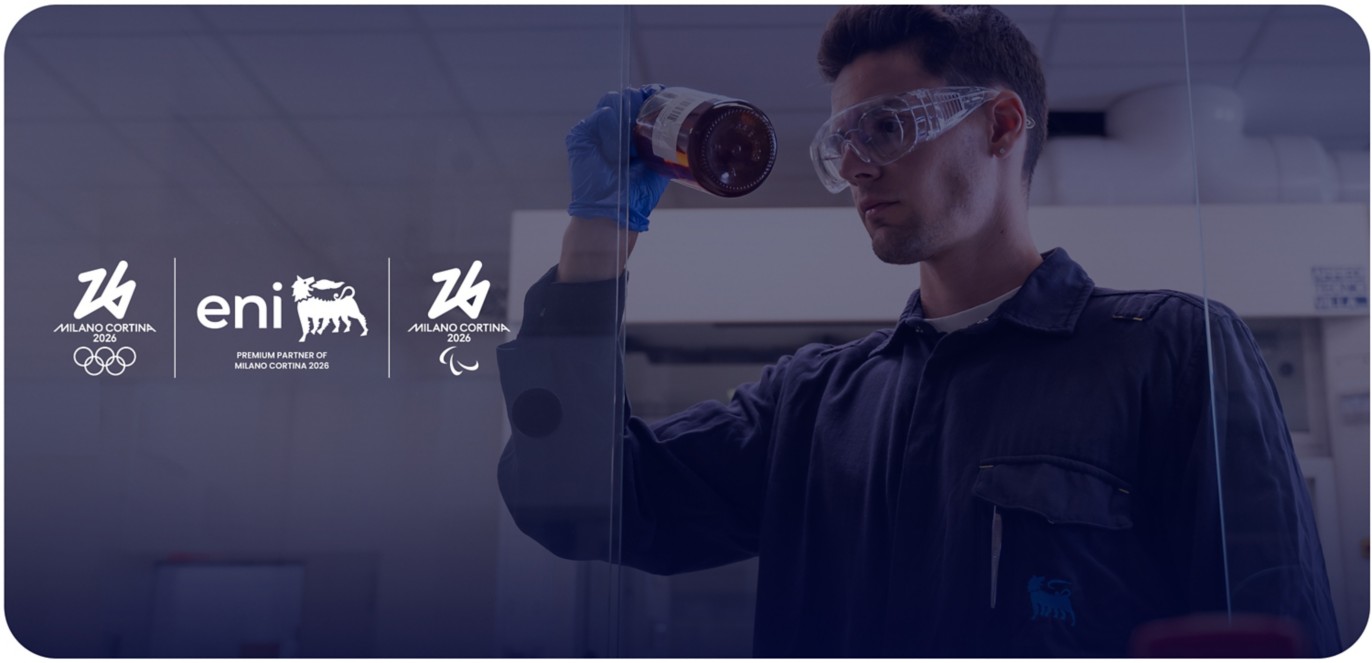 Ricercatore in laboratorio con camice Eni, accanto ai loghi delle Olimpiadi e Paralimpiadi Milano Cortina 2026