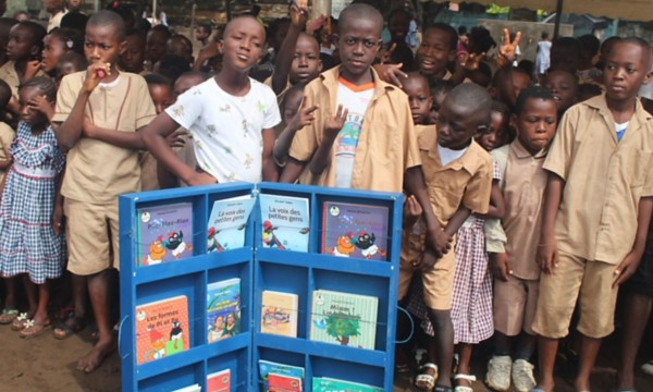 Bimbi africani  in posa davanti a una teca di libri