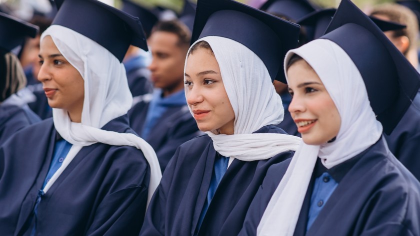 Three female students sitting next to each other during the end-of-course ceremony