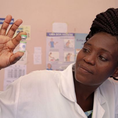African woman holds liquid medication in her hand