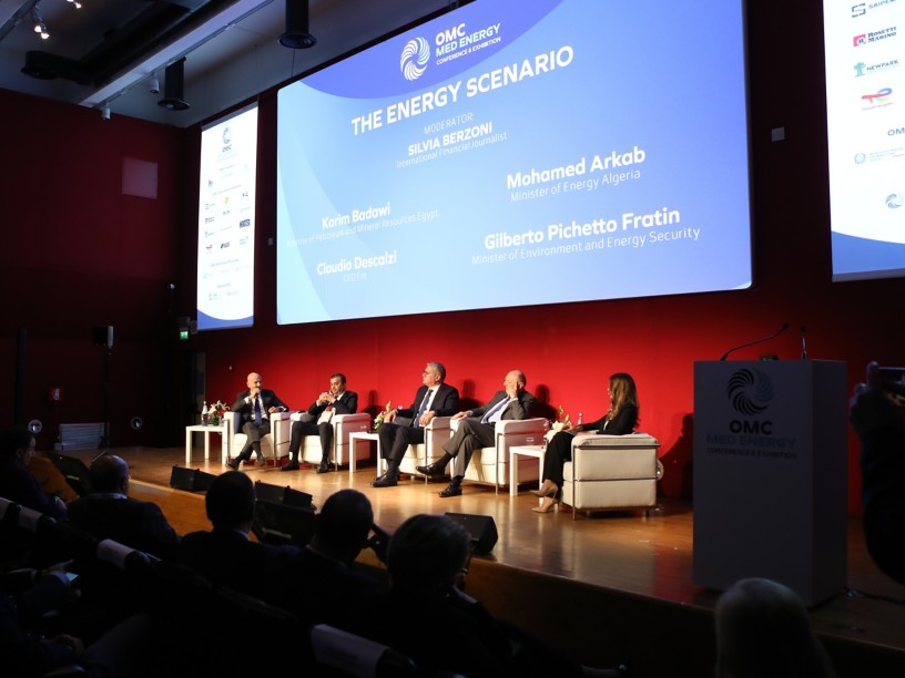 Cinque persone parlano su un palco