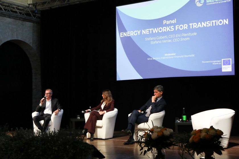 Tre persone parlano a una conferenza