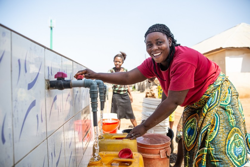 Donne africane che prendono acqua dalla fontana