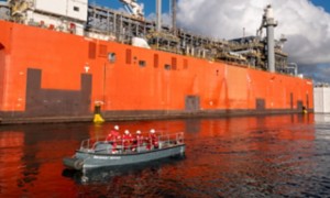 Side view of ship with workers in lifeboat