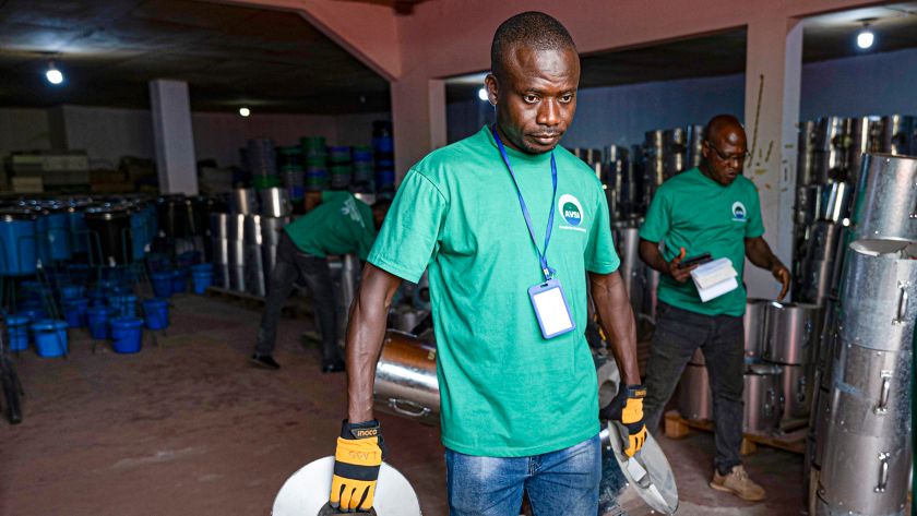 Uomo africano trasporta il piano cottura fuori dal alboratorio di produzione