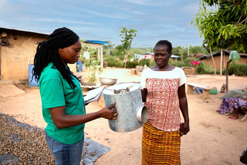 African woman delivers cooking system to village woman in process of delivering stove 