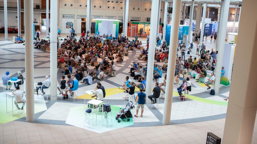 Famiglie e ragazzi seduti negli spazi Eni al Meeting di Rimini 2024.