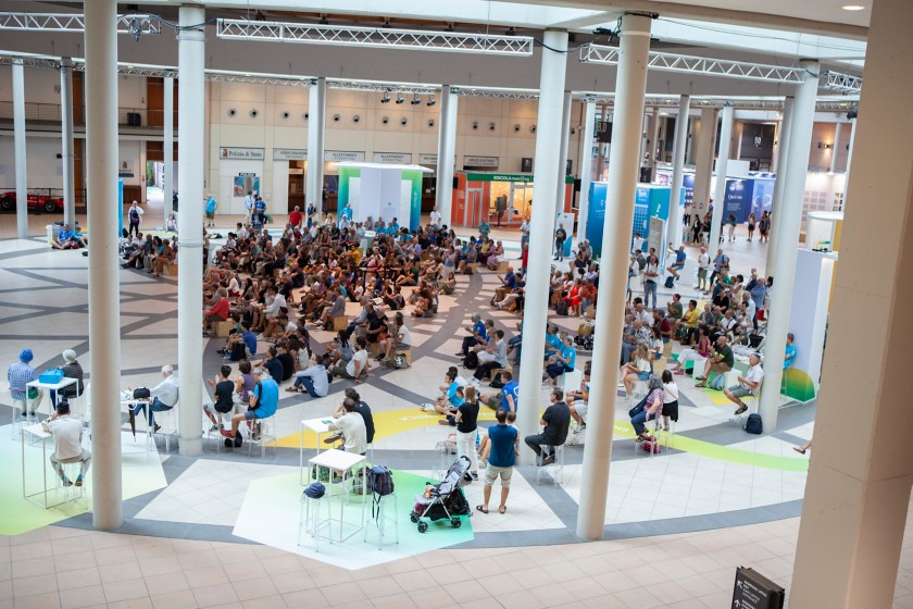 Famiglie e ragazzi seduti negli spazi Eni al Meeting di Rimini 2024.