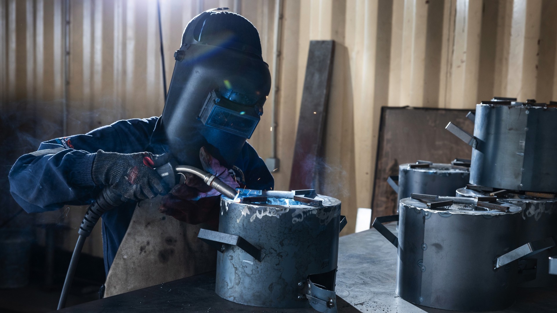 A man is manufacturing improved cookstoves.