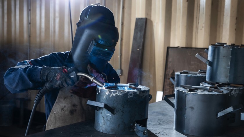 A man is manufacturing improved cookstoves.