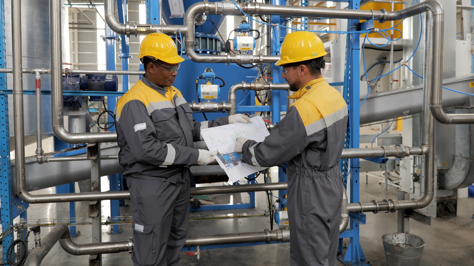 Two workers look at the map in the machine room
