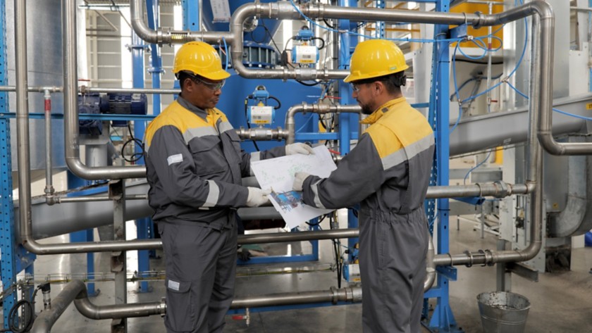 Two workers look at the map in the machine room