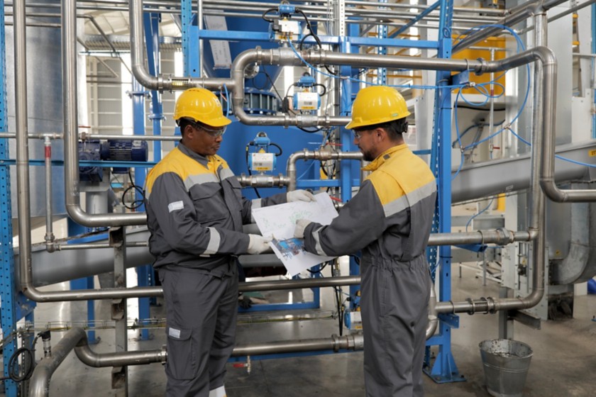 Two workers look at the map in the machine room