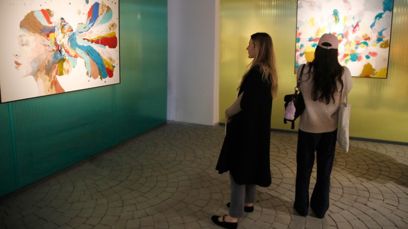 Two women look at two artworks at Arte al Gazometro