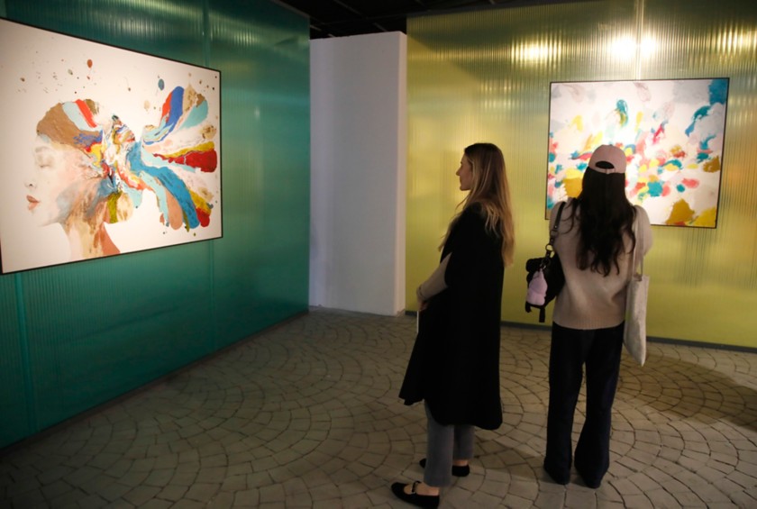 Two women look at two artworks at Arte al Gazometro