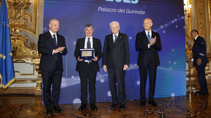 Lo scienziato francese Philippe Ciais è in piedi su un palco, mentre tiene in mano il Premio Soluzioni Ambientali Avanzate