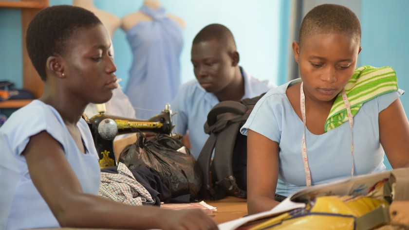 African women seamstresses study a book