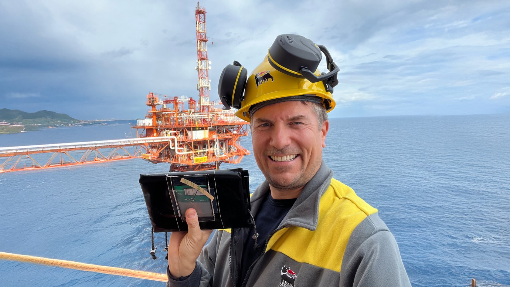 Tecnico al lavoro su una piattaforma offshore mostra il dispositivo digitale GSN