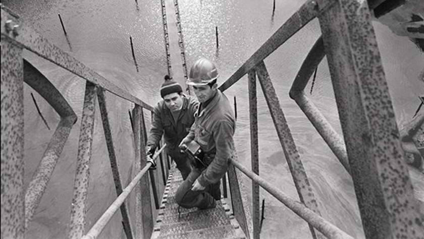 Due operai ritratti su un montacarichi in una foto d'epoca