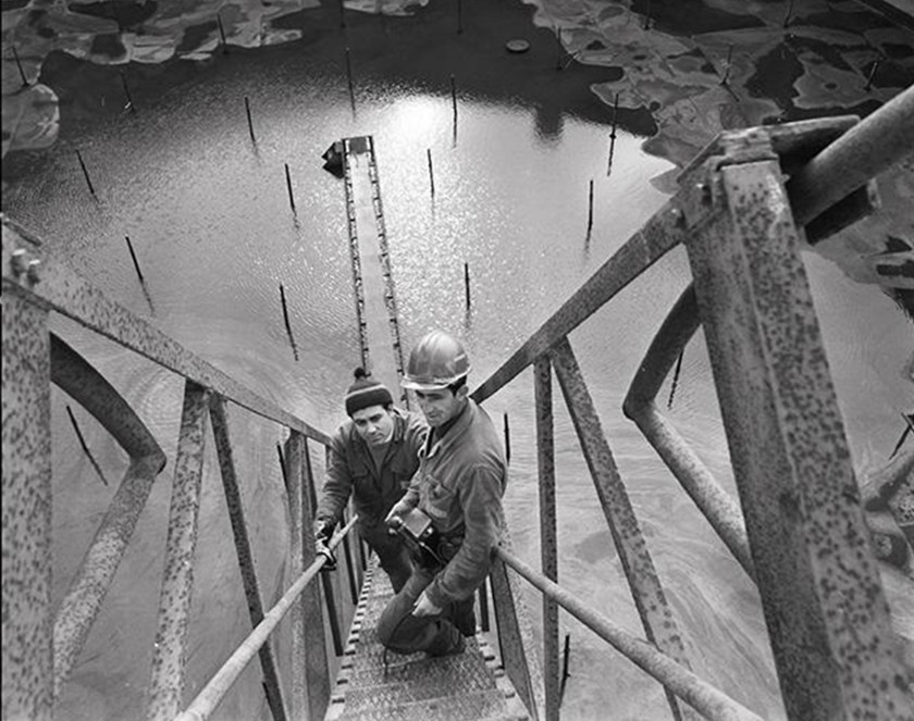 Due operai ritratti su un montacarichi in una foto d'epoca