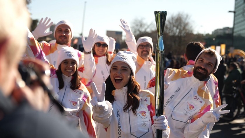 I tedofori posano davanti ai fotografi durante il passaggio della Torcia Olimpica a Milano